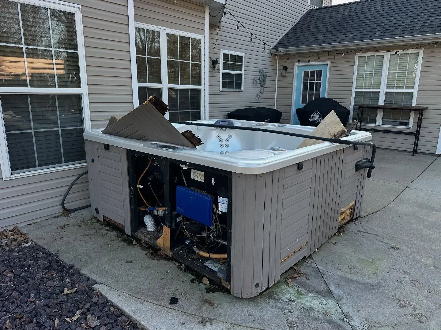 A hot tub is sitting in the backyard of a house.