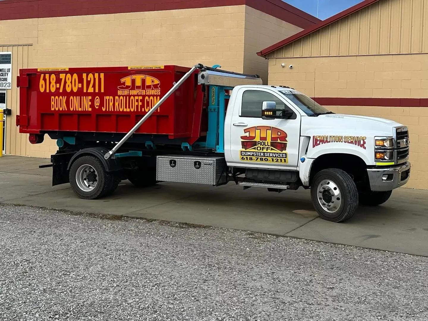 A dump truck is parked in front of a building.
