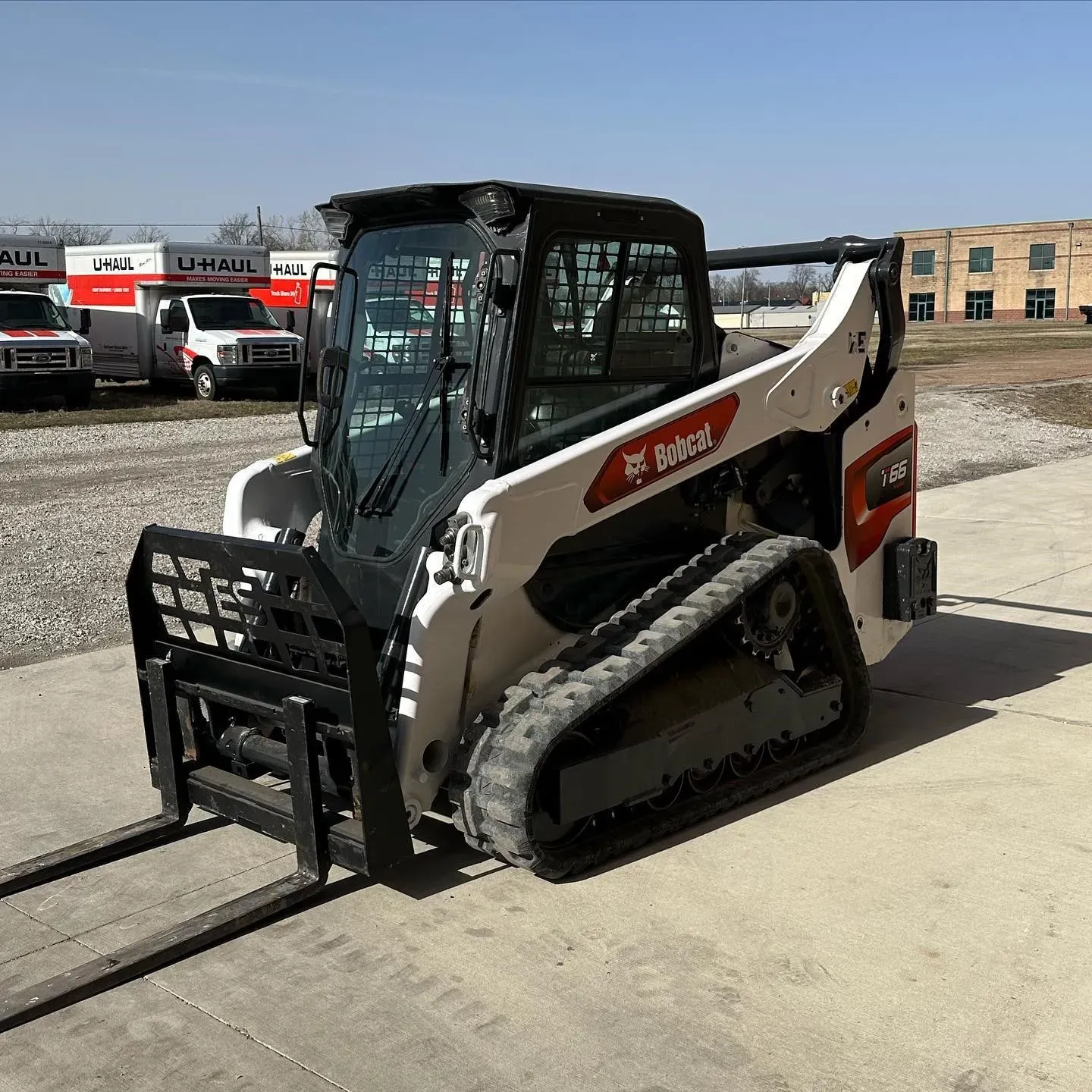 A bobcat skid steer is parked on the side of the road