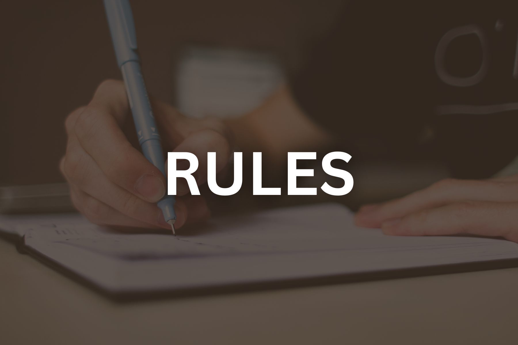 Photo of someone writing with a black  overlay and reads rules
