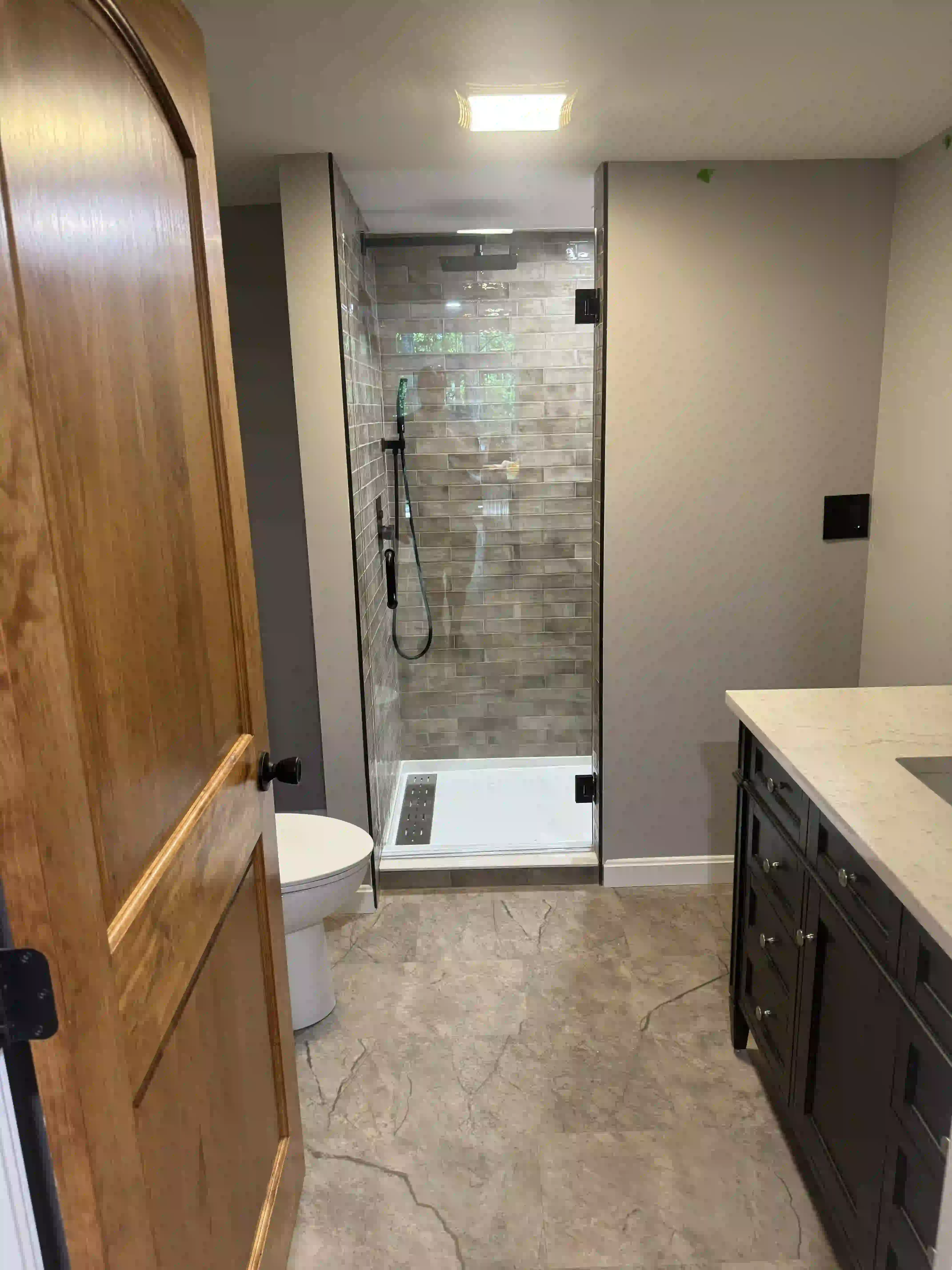 A bathroom with a walk in shower and a toilet.