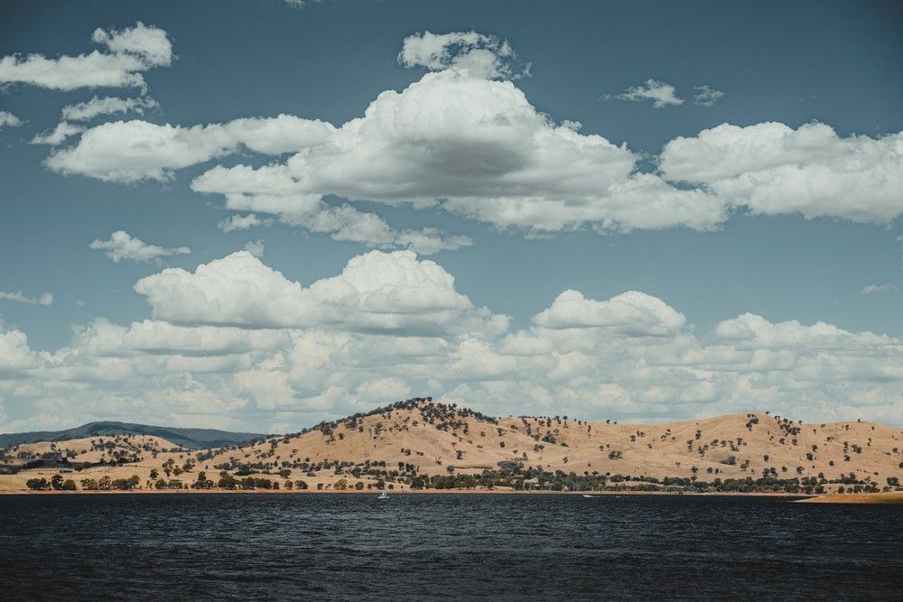 Blue Sky with Fluffy White Clouds Over a Dark Lake — Cartech Australia in Wodonga, NSW