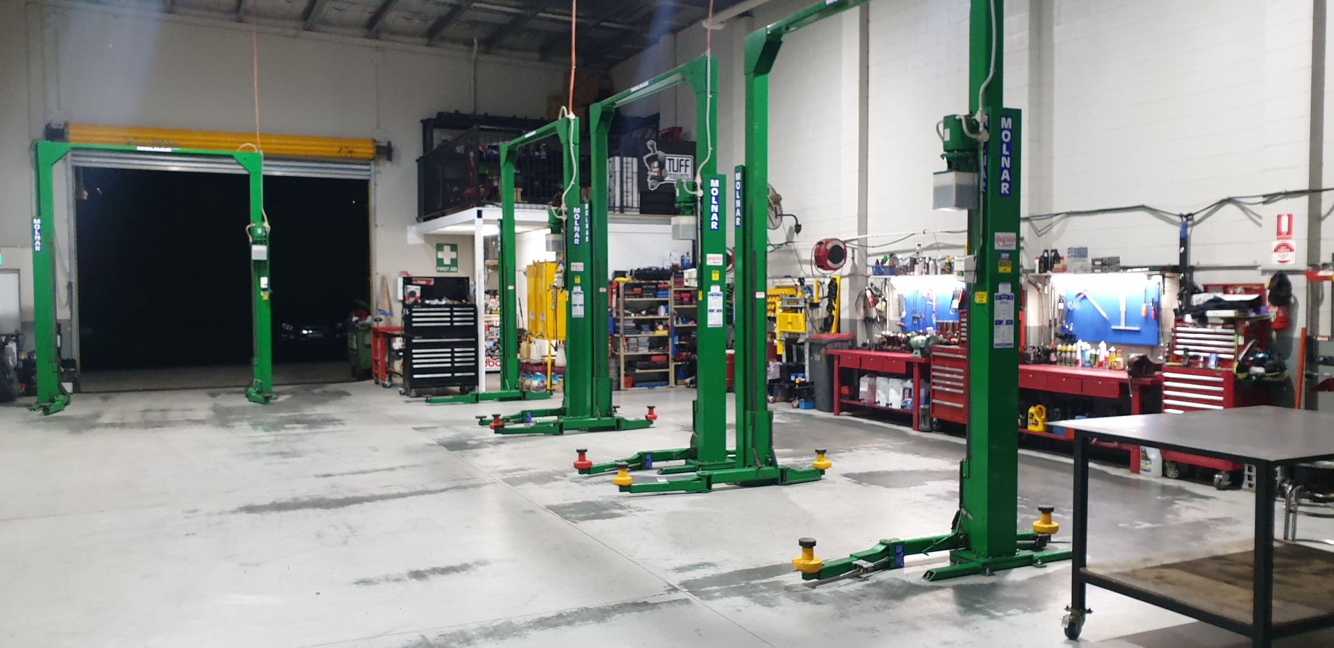Inside an auto repair shop with multiple green car lifts — Cartech Australia in Albury, NSW