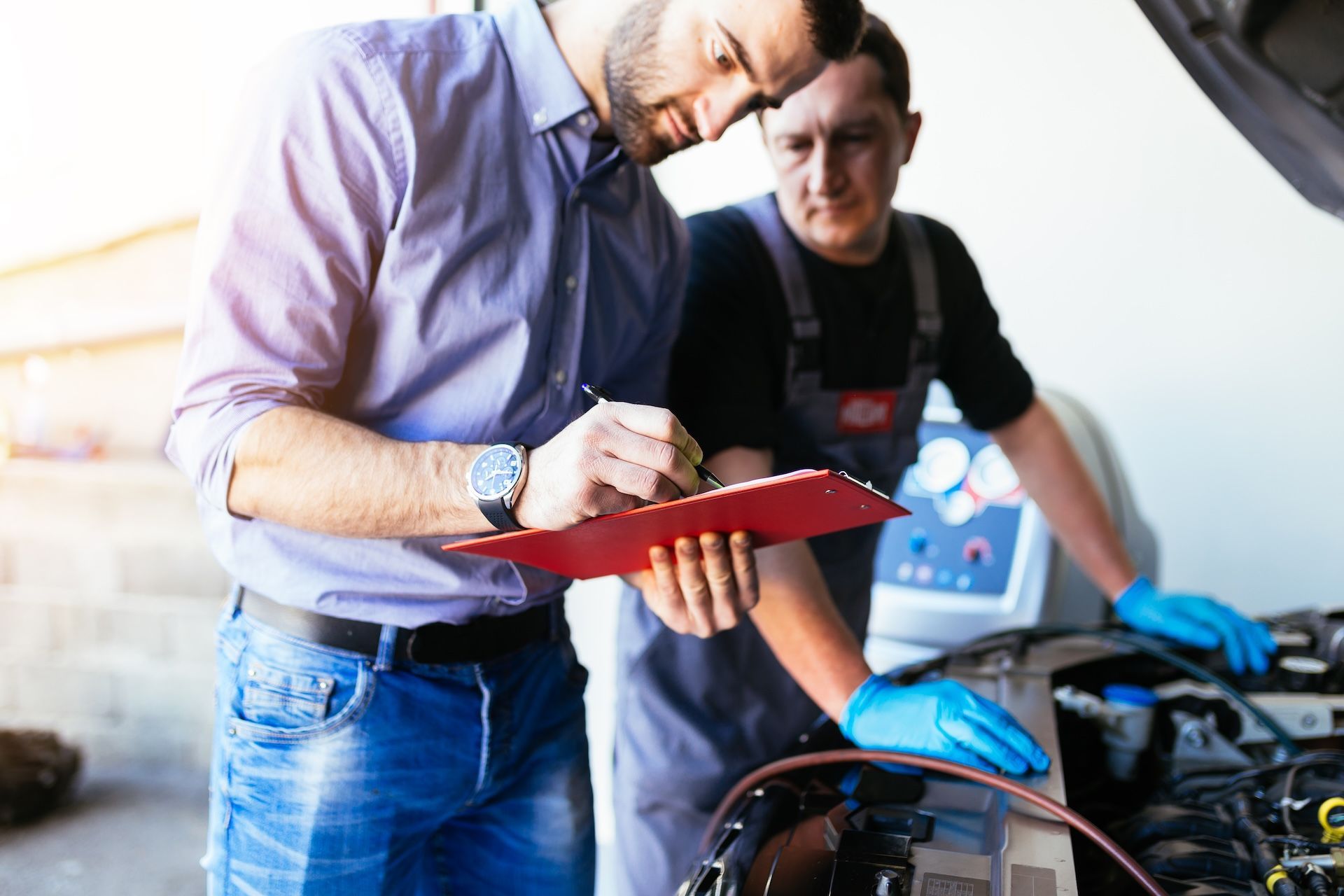 Man in A Shirt Writes on Clipboard as Mechanic — Cartech Australia in Albury, NSW