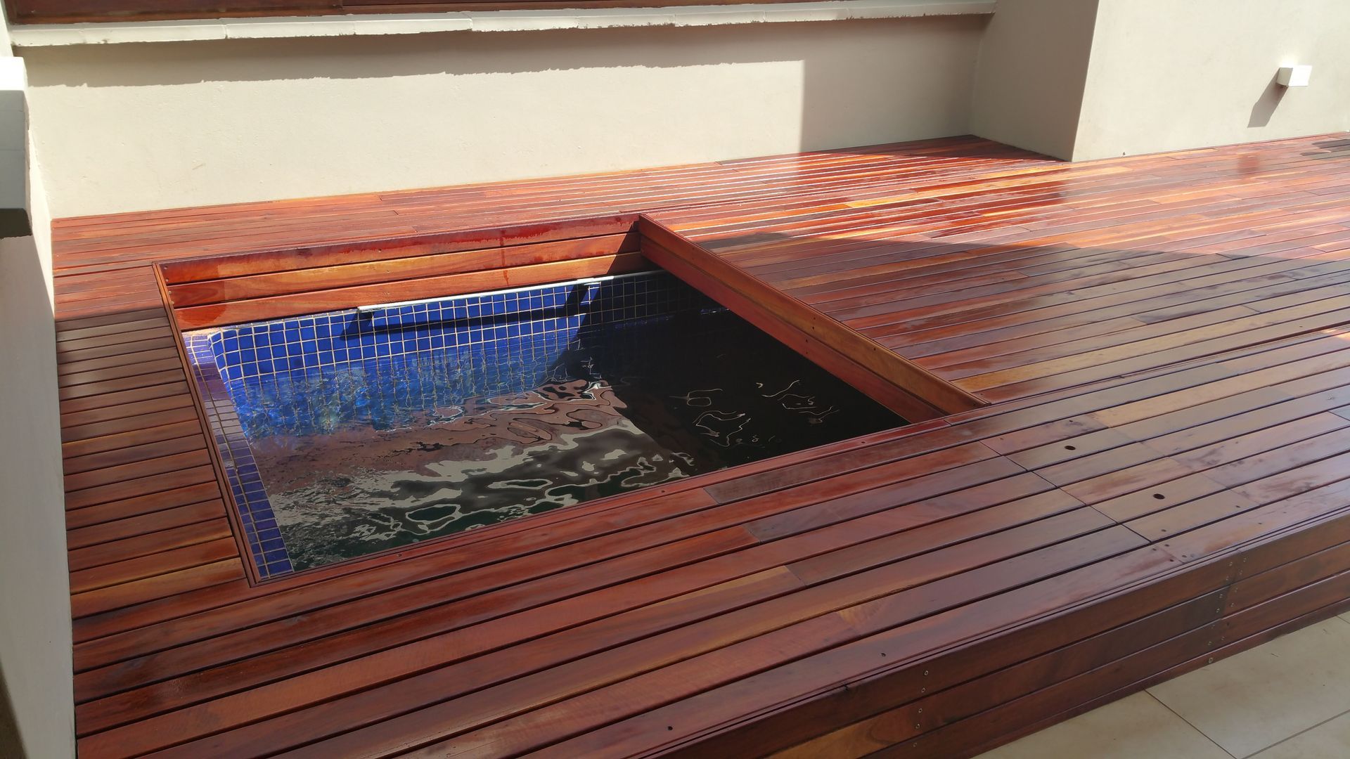 A wooden deck with a pool in the middle of it