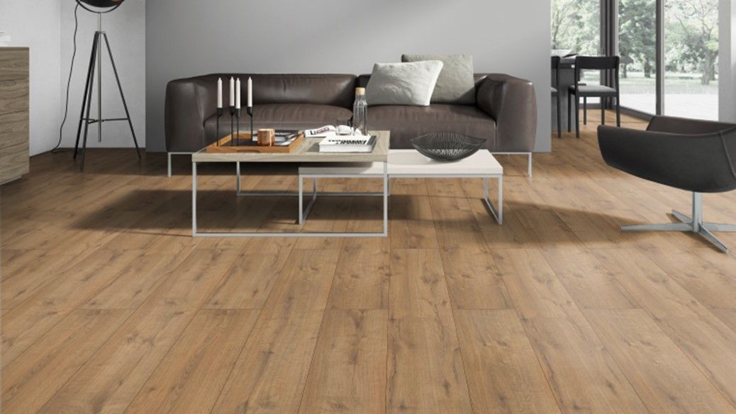 A living room with hardwood floors , a couch , a chair , and a coffee table.