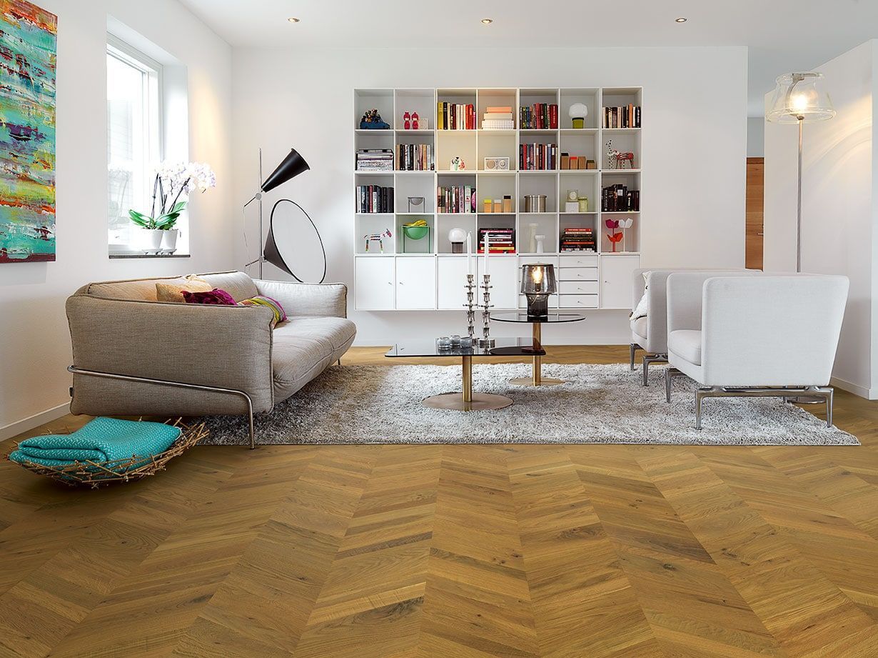 A living room with a couch , chairs , and a bookshelf.