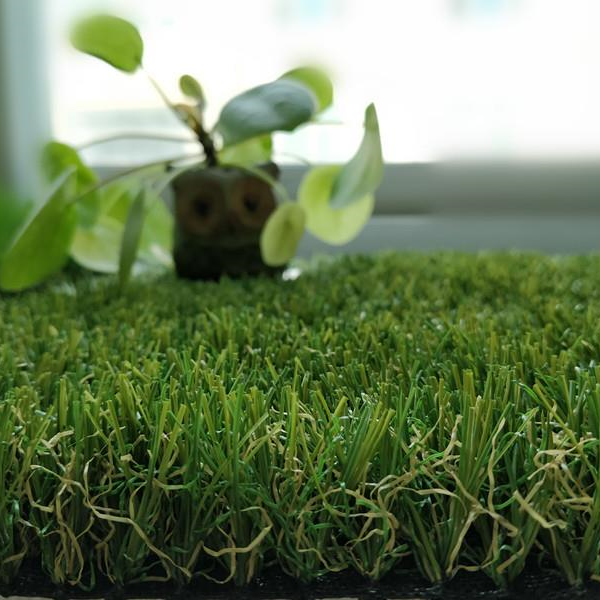 A plant in a pot is sitting on top of a lush green field of grass.