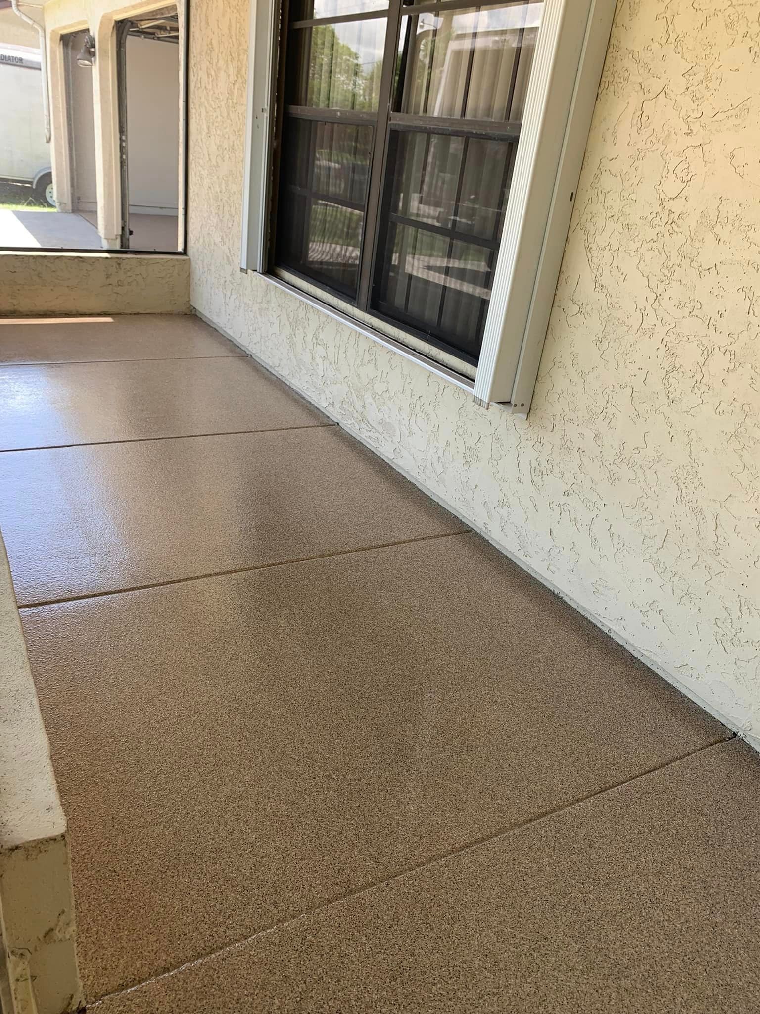 Patio with pebble-like flooring and a window. Tan walls, bright light.