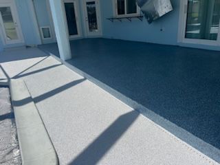 Patio with a blue and white speckled epoxy floor. Light blue walls, glass doors, and a column are visible.