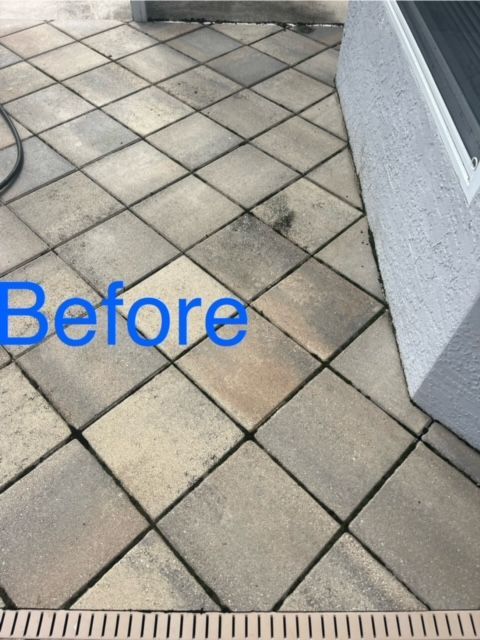 Dirty, diamond-patterned stone patio before cleaning. Black grout lines and a white wall are visible.
