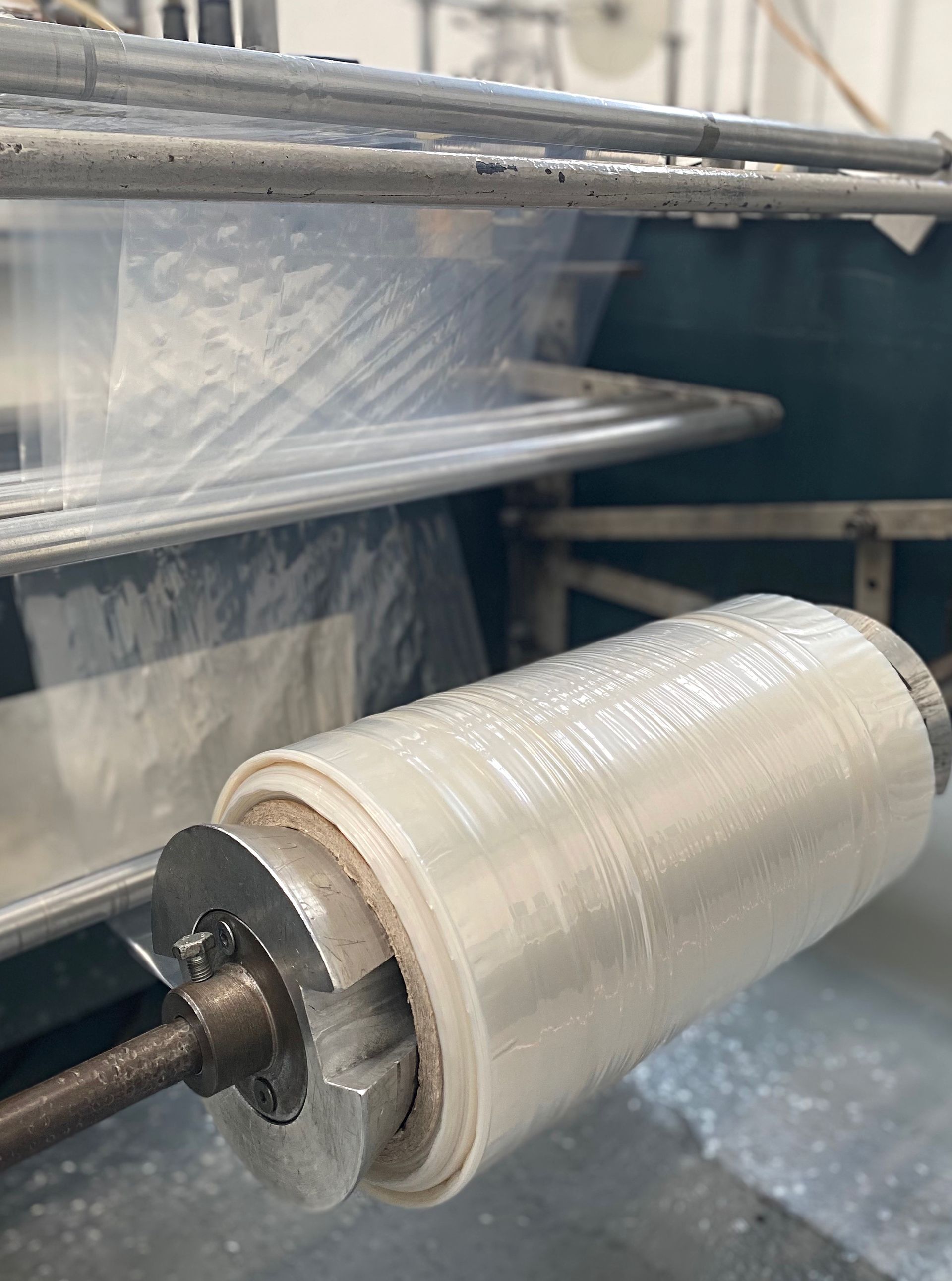 A roll of plastic is being rolled on a machine
