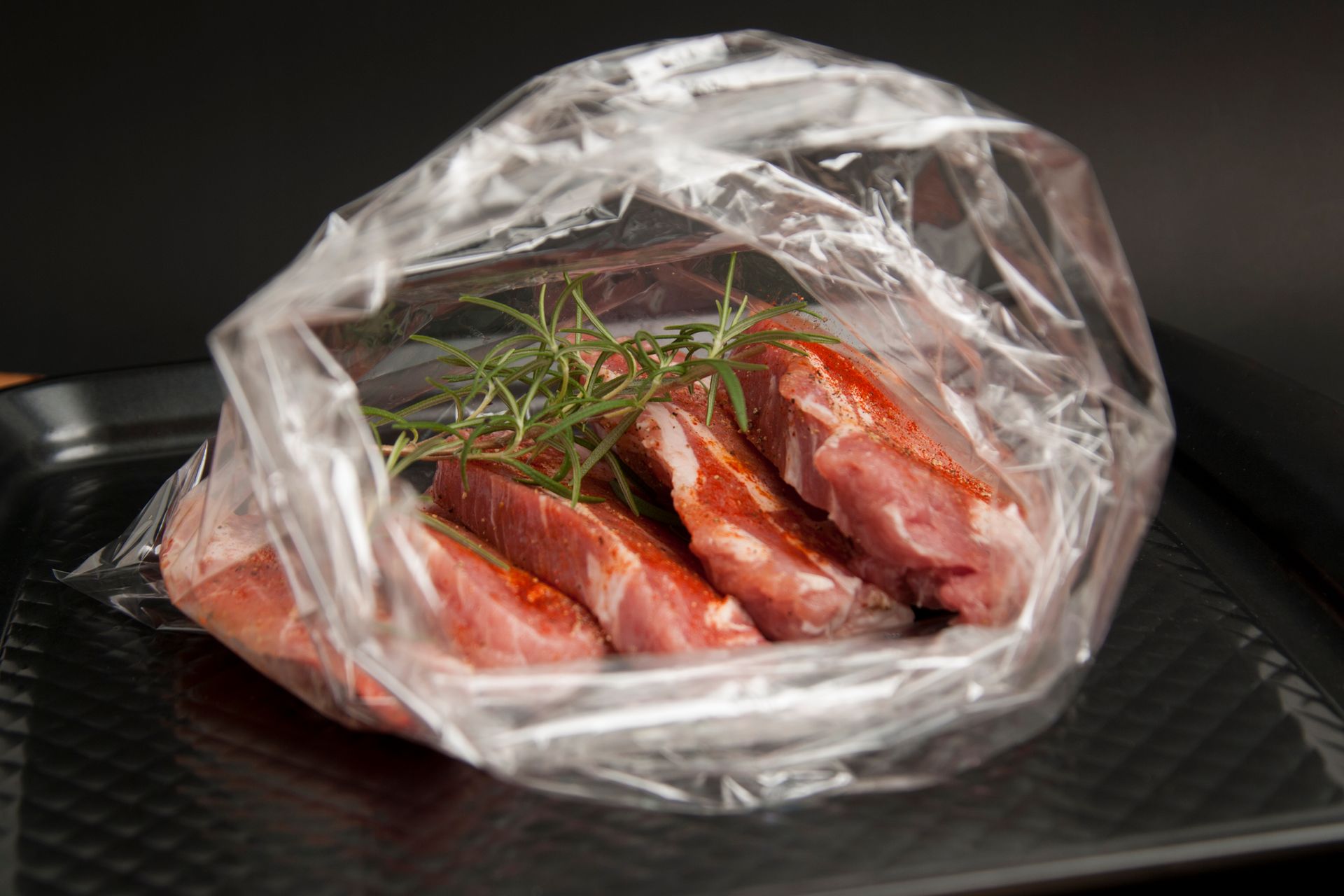A piece of meat in a plastic bag on a tray