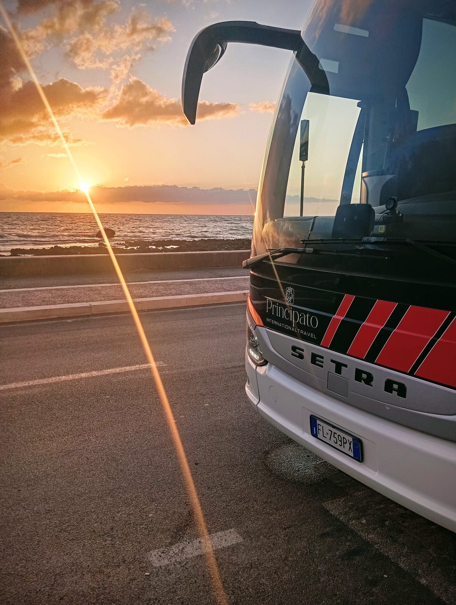 Autobus turistico bianco parcheggiato davanti al Colosseo a Roma, Italia.