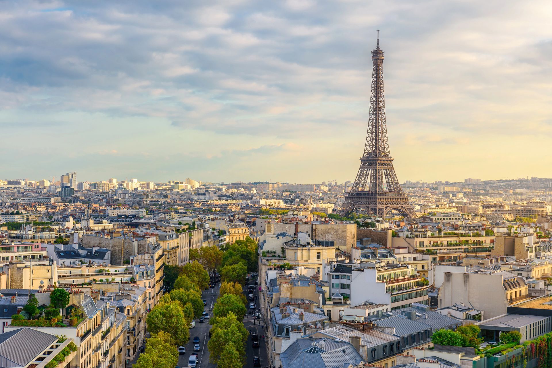 Lo skyline di Parigi al tramonto con la Torre Eiffel che svetta sui tetti della città.