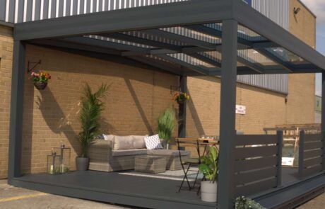 A patio with a couch and chairs under a canopy in front of a building.