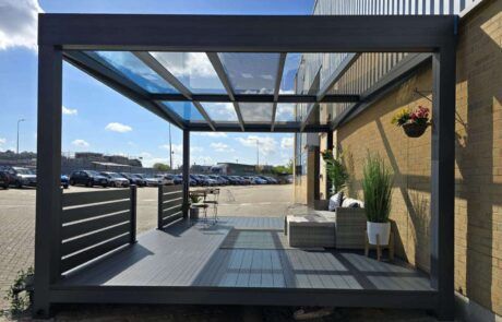 A patio with a glass roof and a couch underneath it.