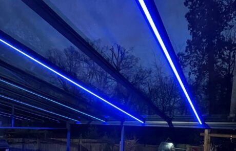 A carport with blue lights on it at night.