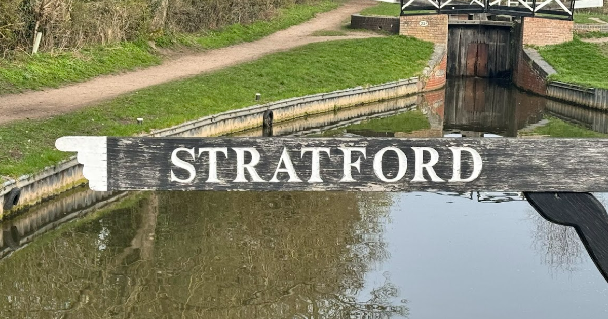 STRATFORD sign over a canal lock with grassy banks and stone walls