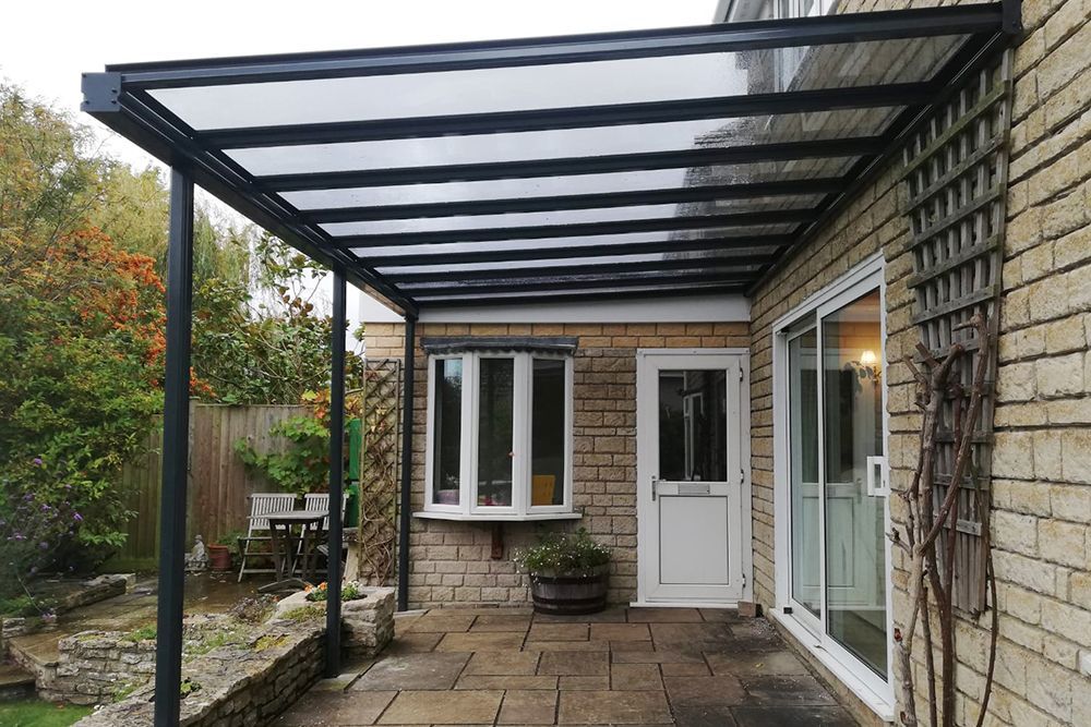 A brick house with a patio and a canopy over it.
