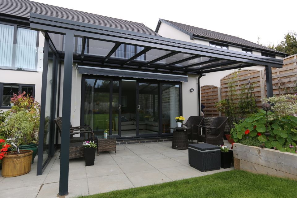 There is a patio with a canopy over it in the backyard of a house.