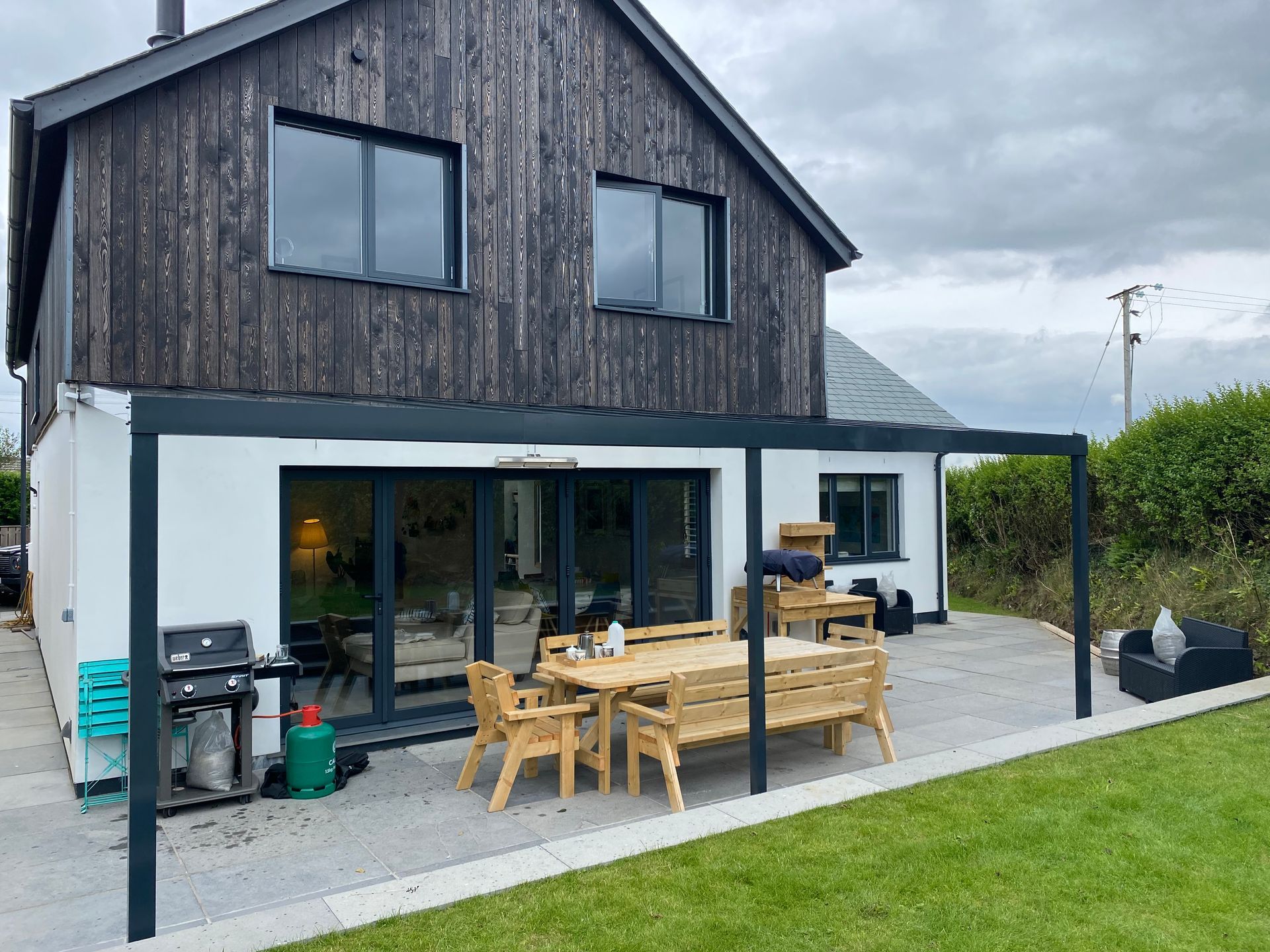 A house with a patio area and a table and chairs in front of it.