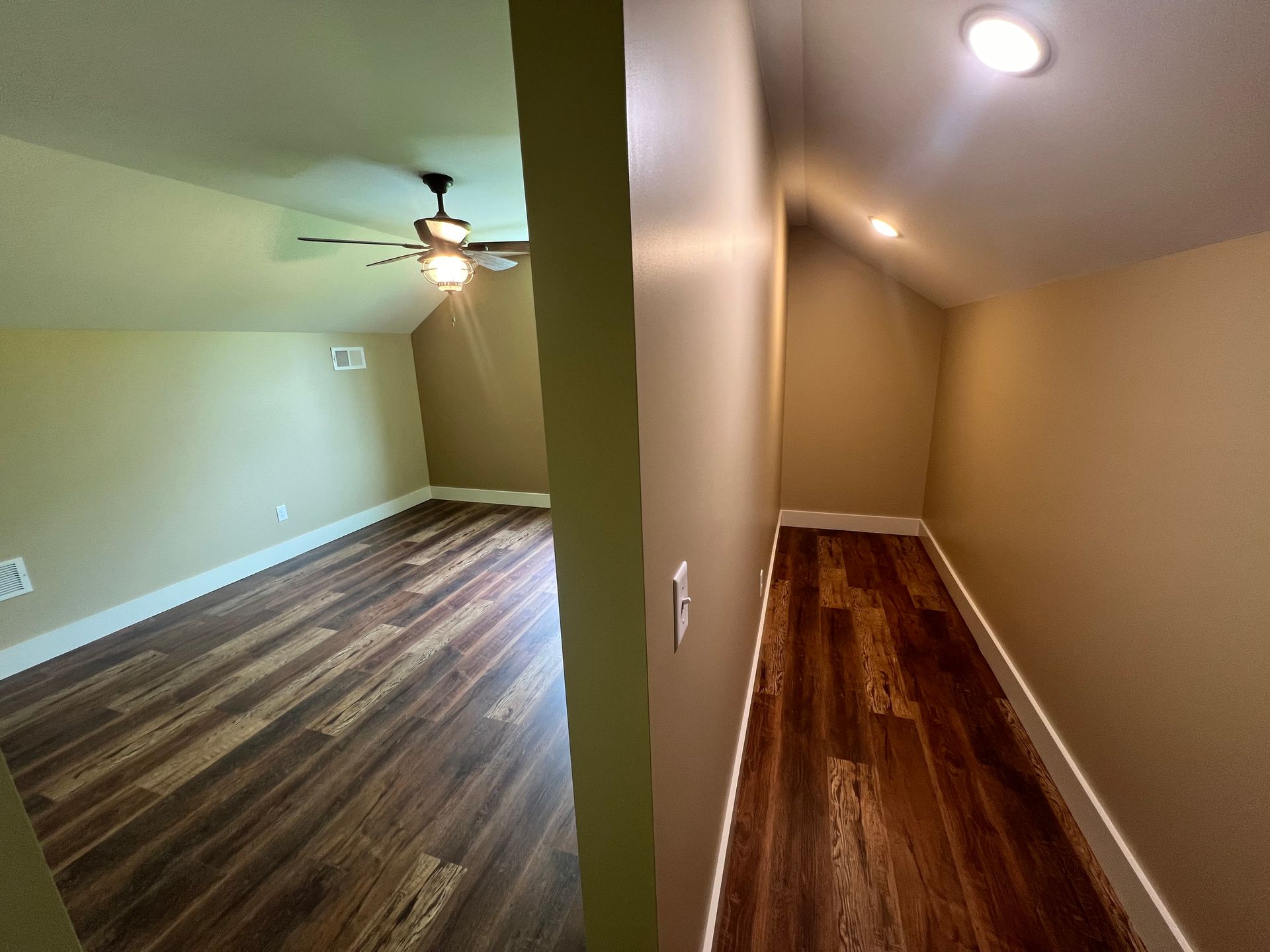 A split view of an attic interior featuring wood-look flooring, light-toned walls, and recessed lighting.