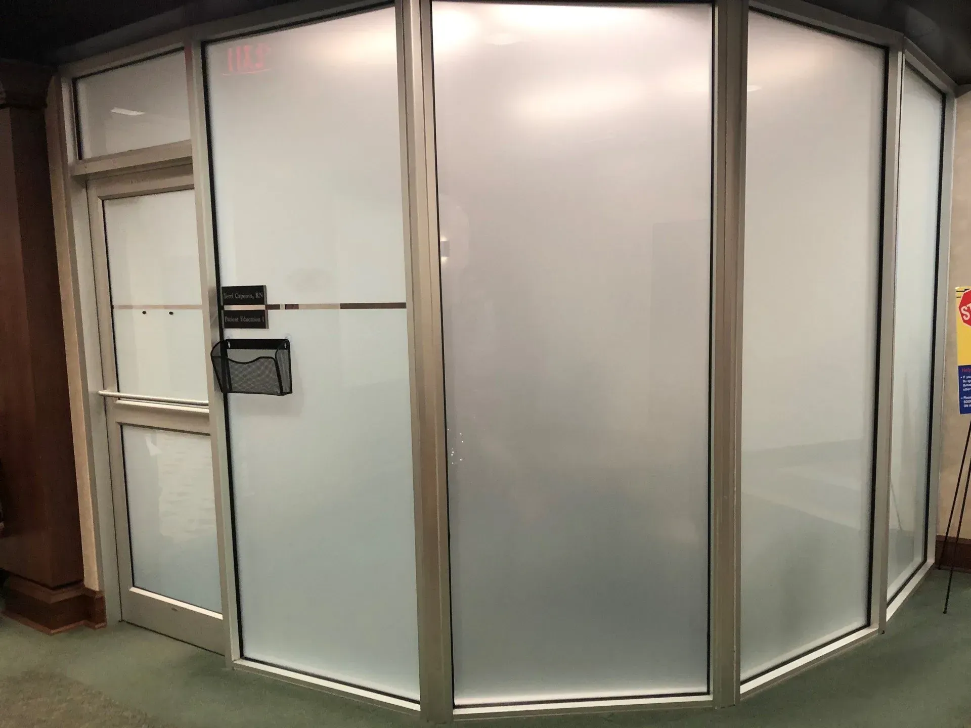 Frosted glass office entrance with curved panels and a wall-mounted keypad lock