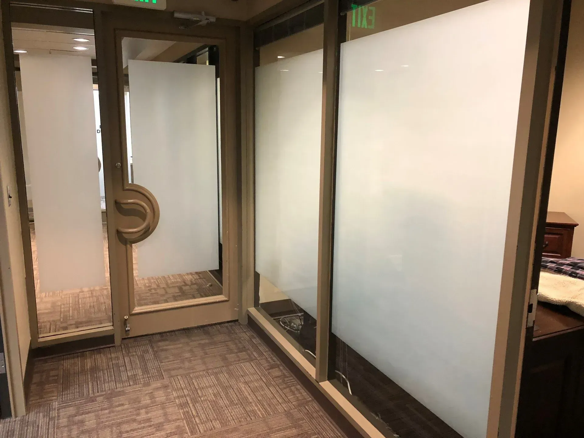Person cleaning a window with a spray bottle and cloth indoors Person cleaning a window with a spray bottle and cloth indoors