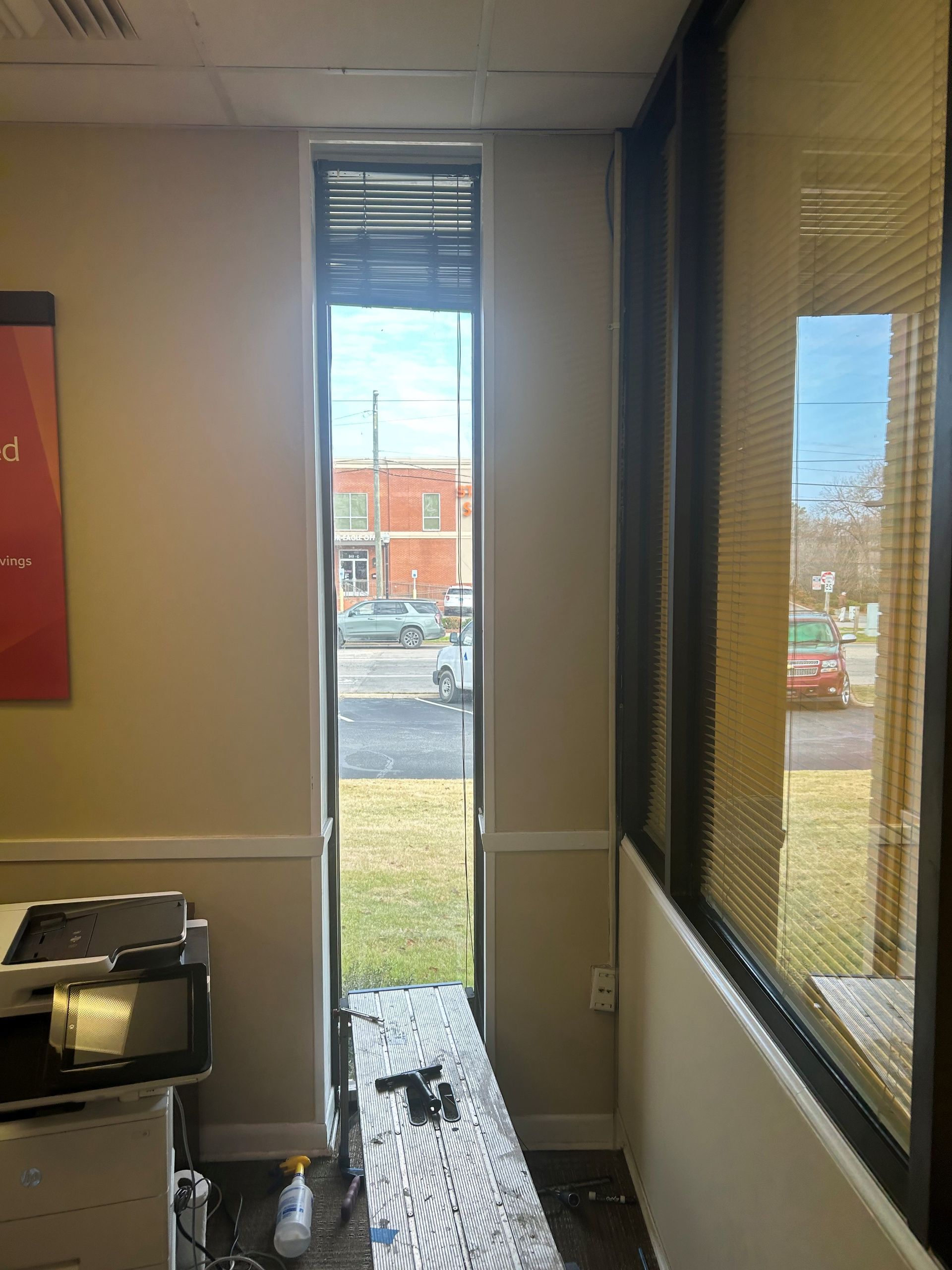 Indoor hallway with narrow windows and a view of a parking lot outside