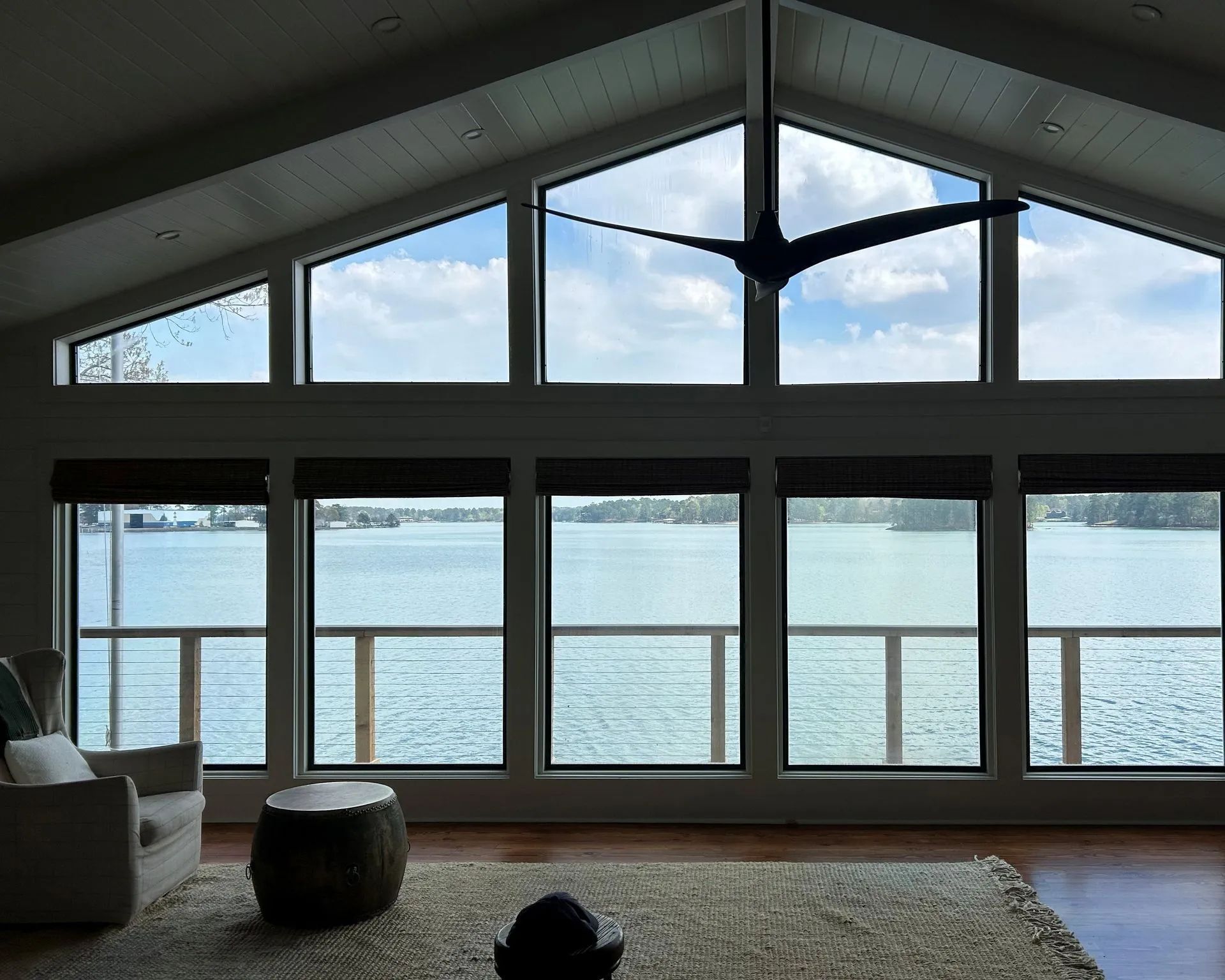 Living room with floor-to-ceiling windows overlooking a calm waterfront