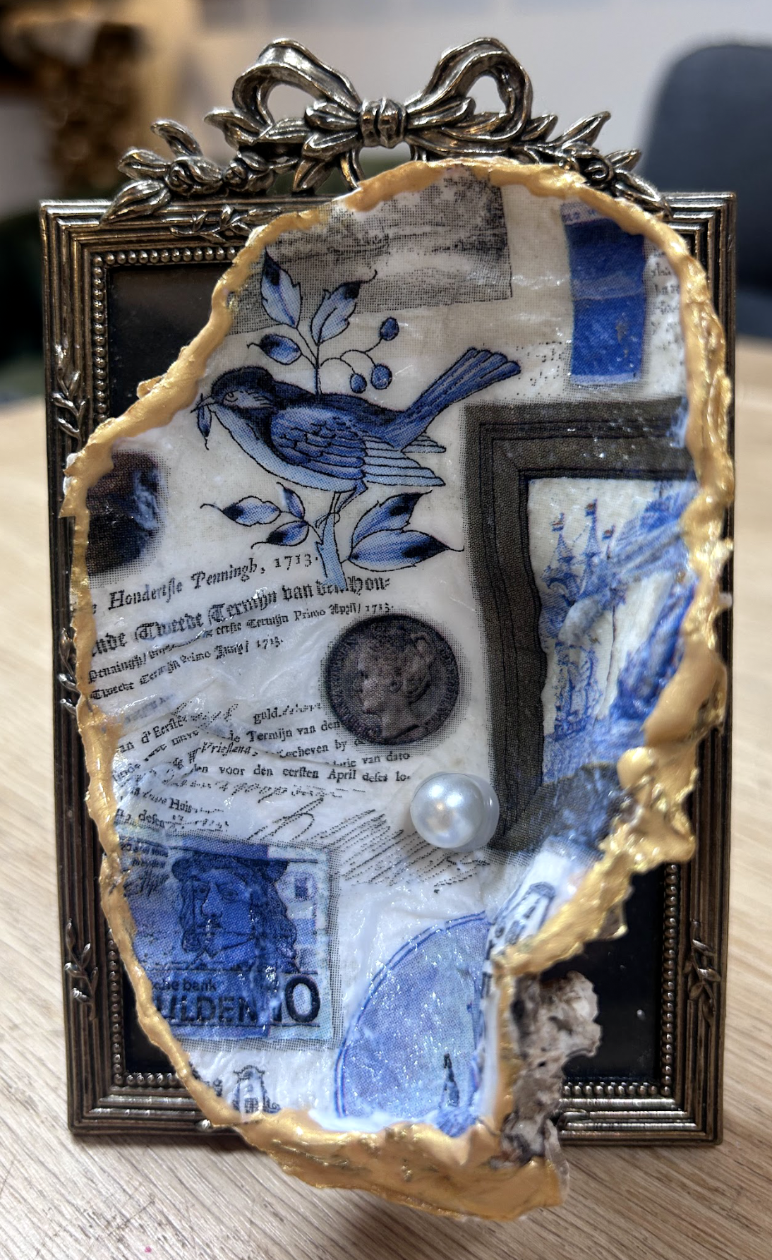 Blauw-zilveren collage in een sierlijke lijst met strik en gescheurde randen, met gestructureerd papier en een parelaccent.