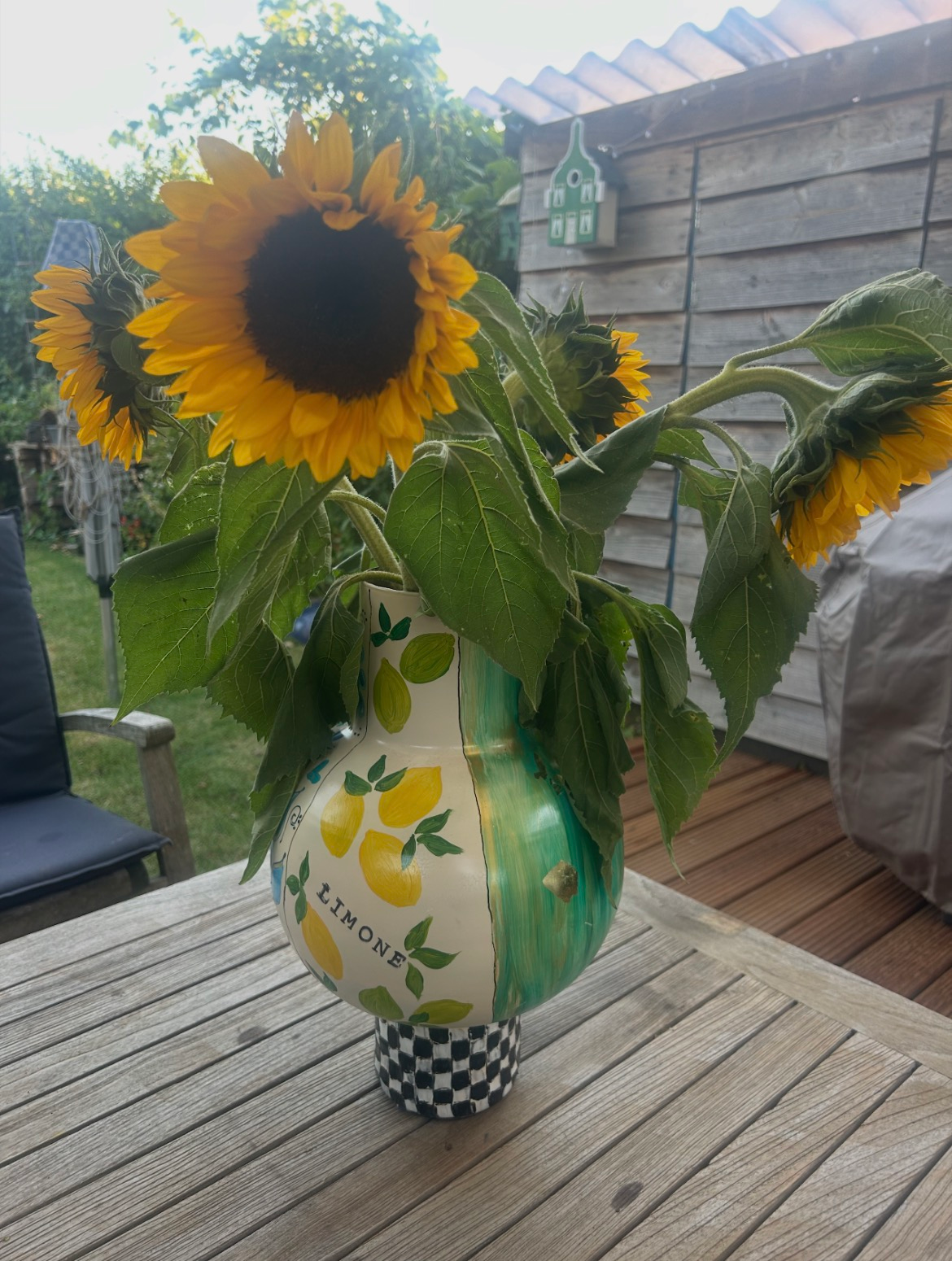 Zes vrouwen poseren binnen met grote, gestreepte en van patronen voorziene decoratieve kalebassen.