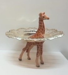 Glazen schaal op een giraffenfiguur tegen een effen witte achtergrond.