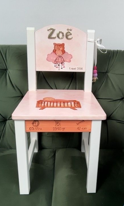 Roze gepersonaliseerde kinderstoel met ‘Zoë’, wit frame en een teddybeermotief voor een groene bank