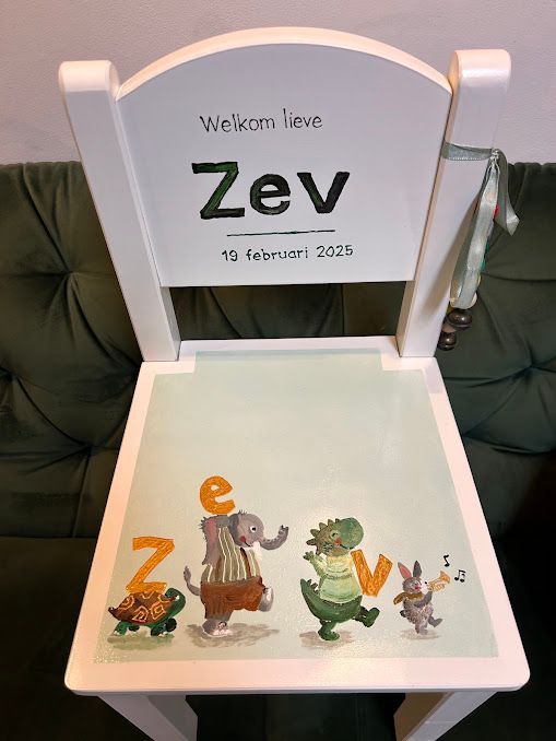 Witte herinneringsdoos met ‘Welcome Here Zev’ en kleurrijke cartoon-dinosaurussen erin.