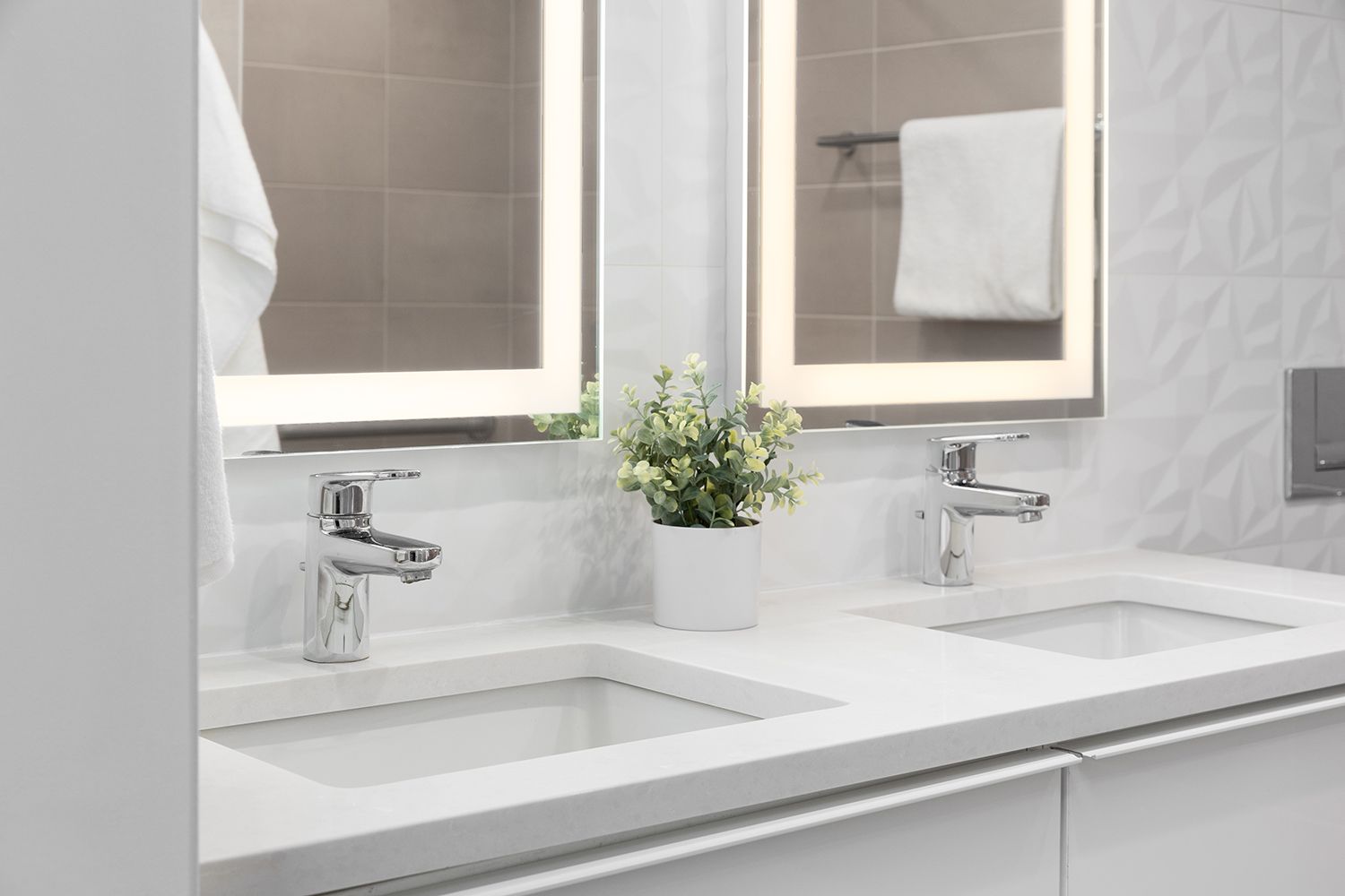 A bathroom with a tub , sink , mirror and two windows.