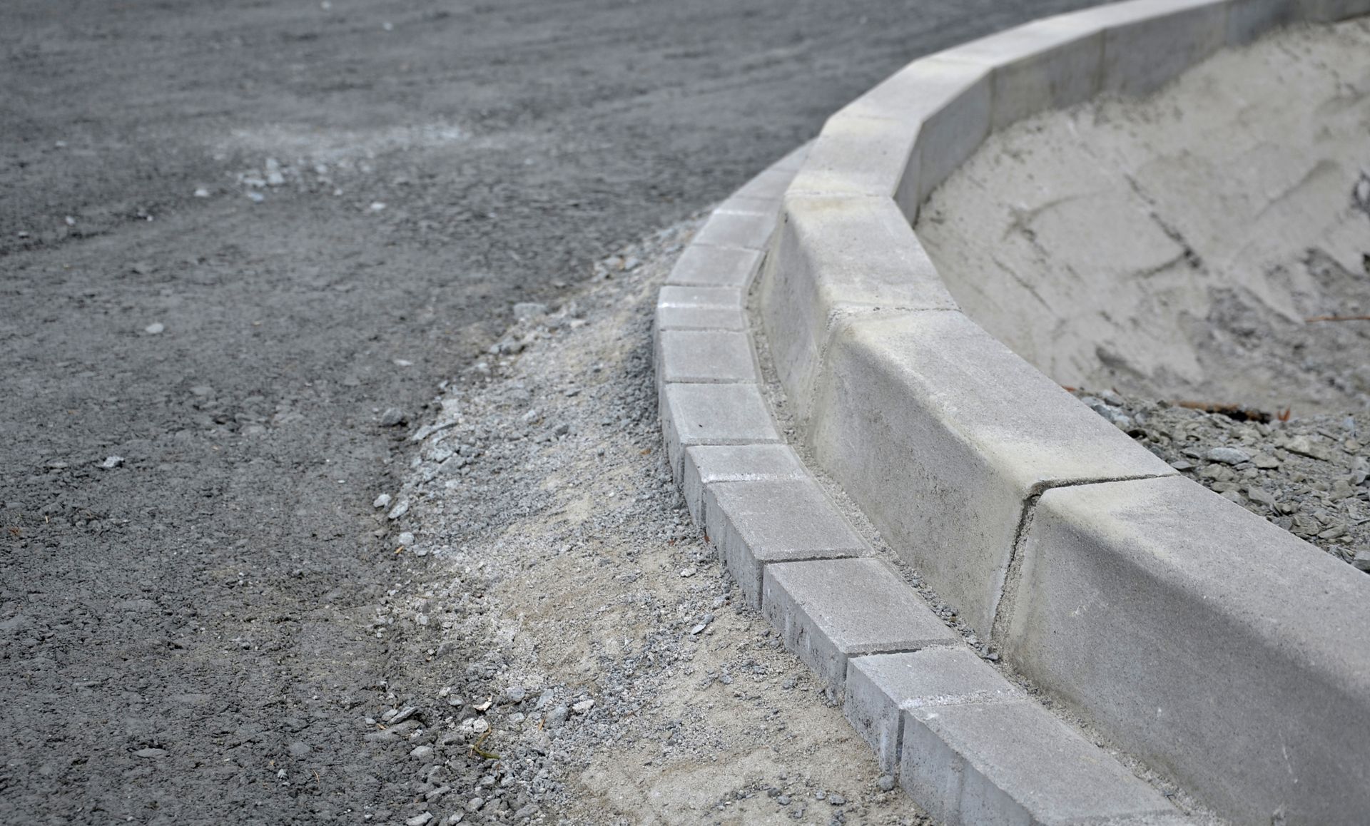 A concrete curb is being built on the side of a road.