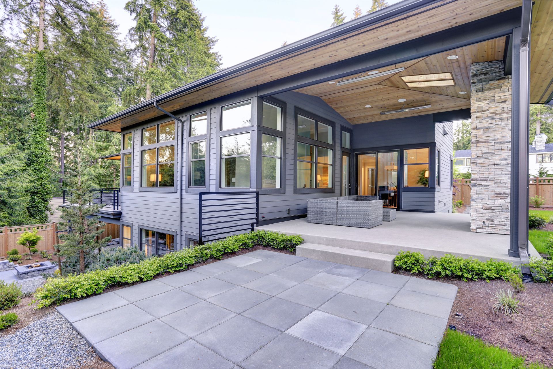 A large house with a lot of windows and a patio in front of it.