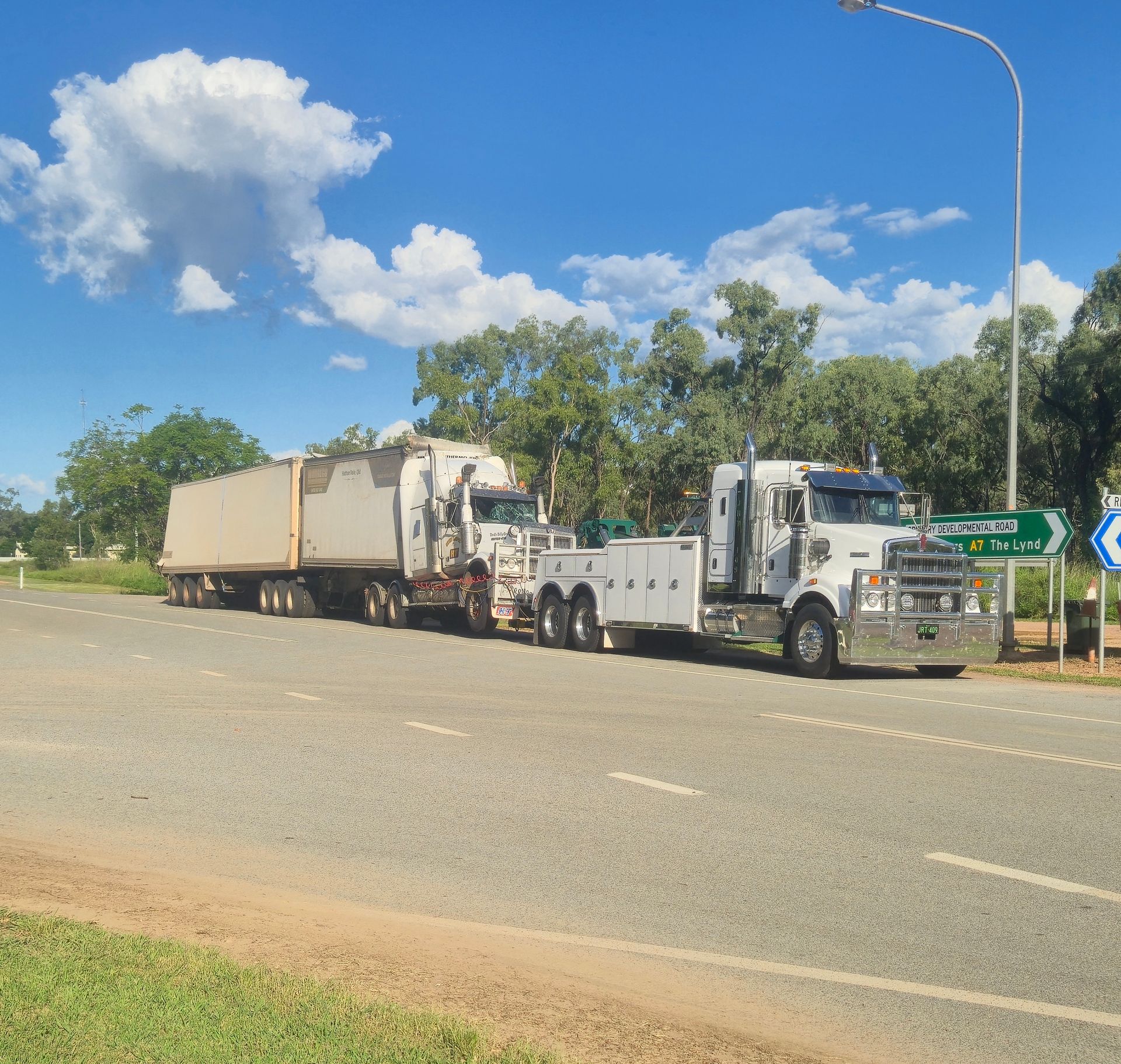A Tow Truck is Towing a Semi Truck on the Side of the Road — Johnson River Towing In Innisfail, QLD