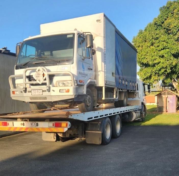 A White Truck is Being Towed by a Tow Truck — Johnson River Towing In Innisfail, QLD
