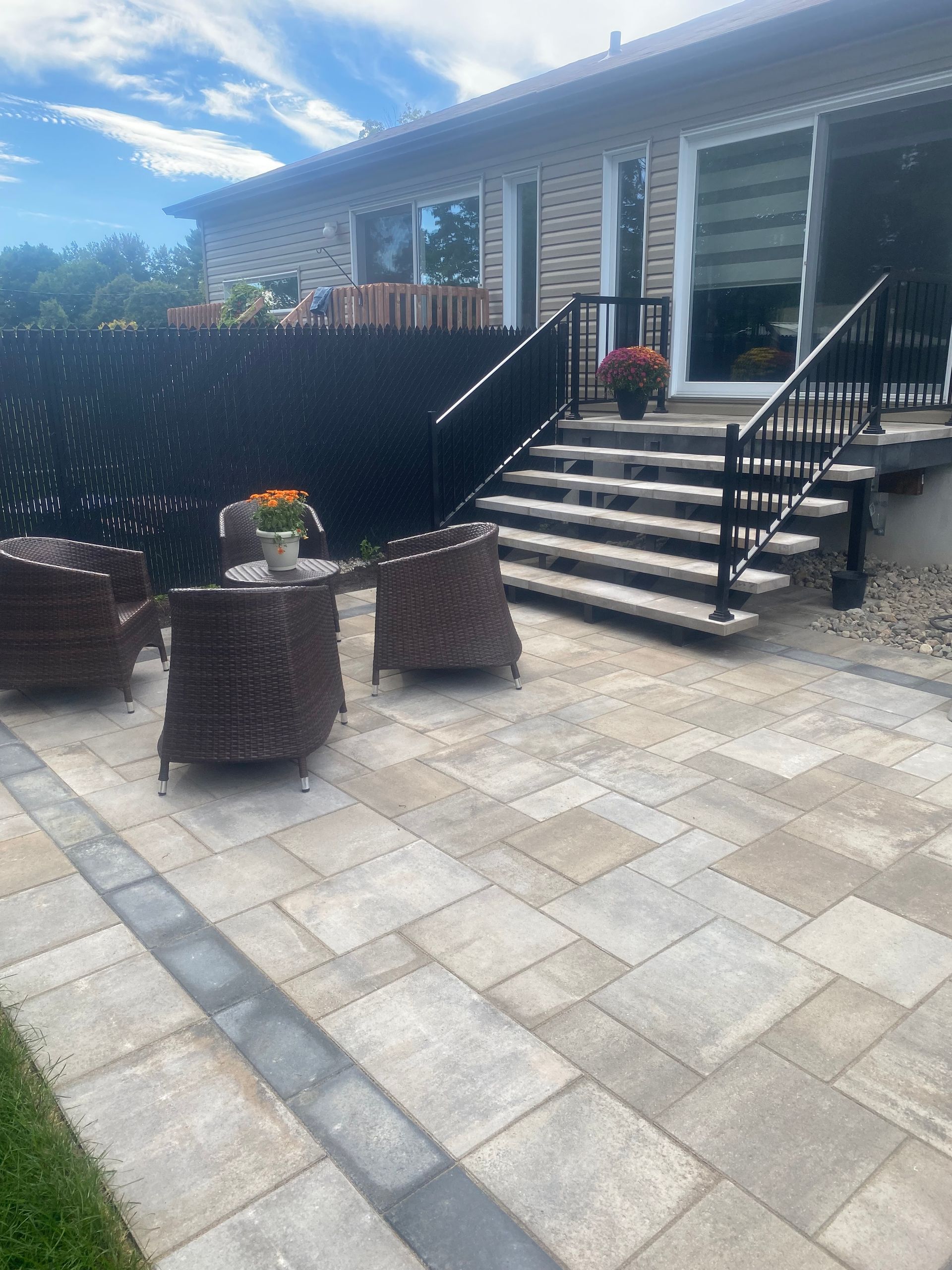 Un patio avec des chaises et une table devant une maison.