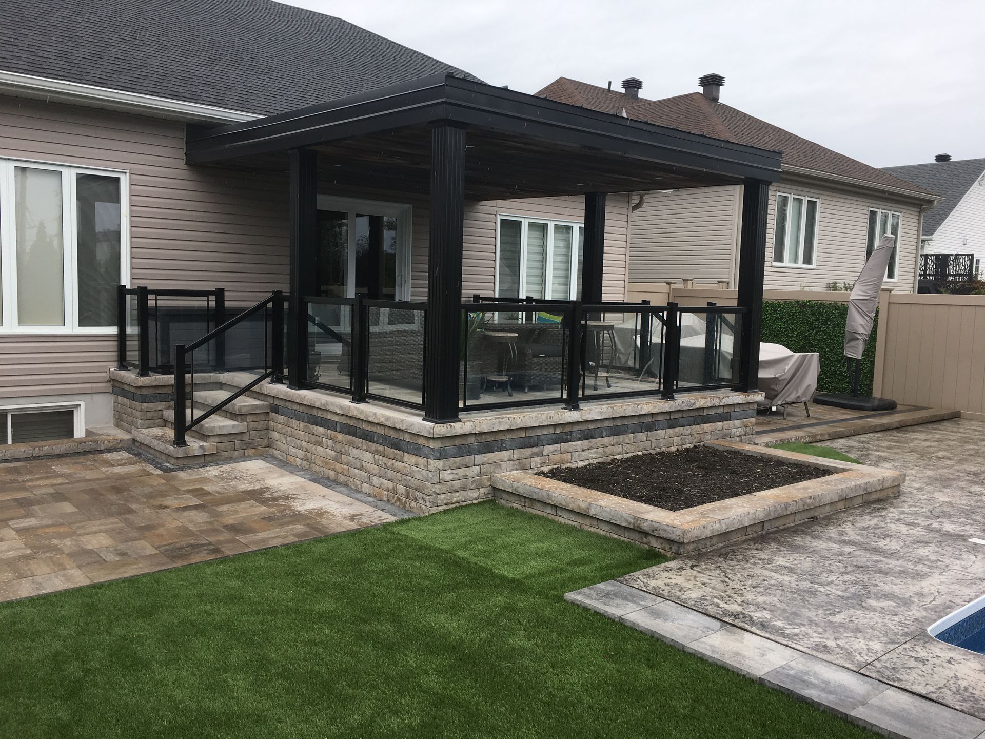 Une maison avec un patio et une piscine dans l'arrière-cour.
