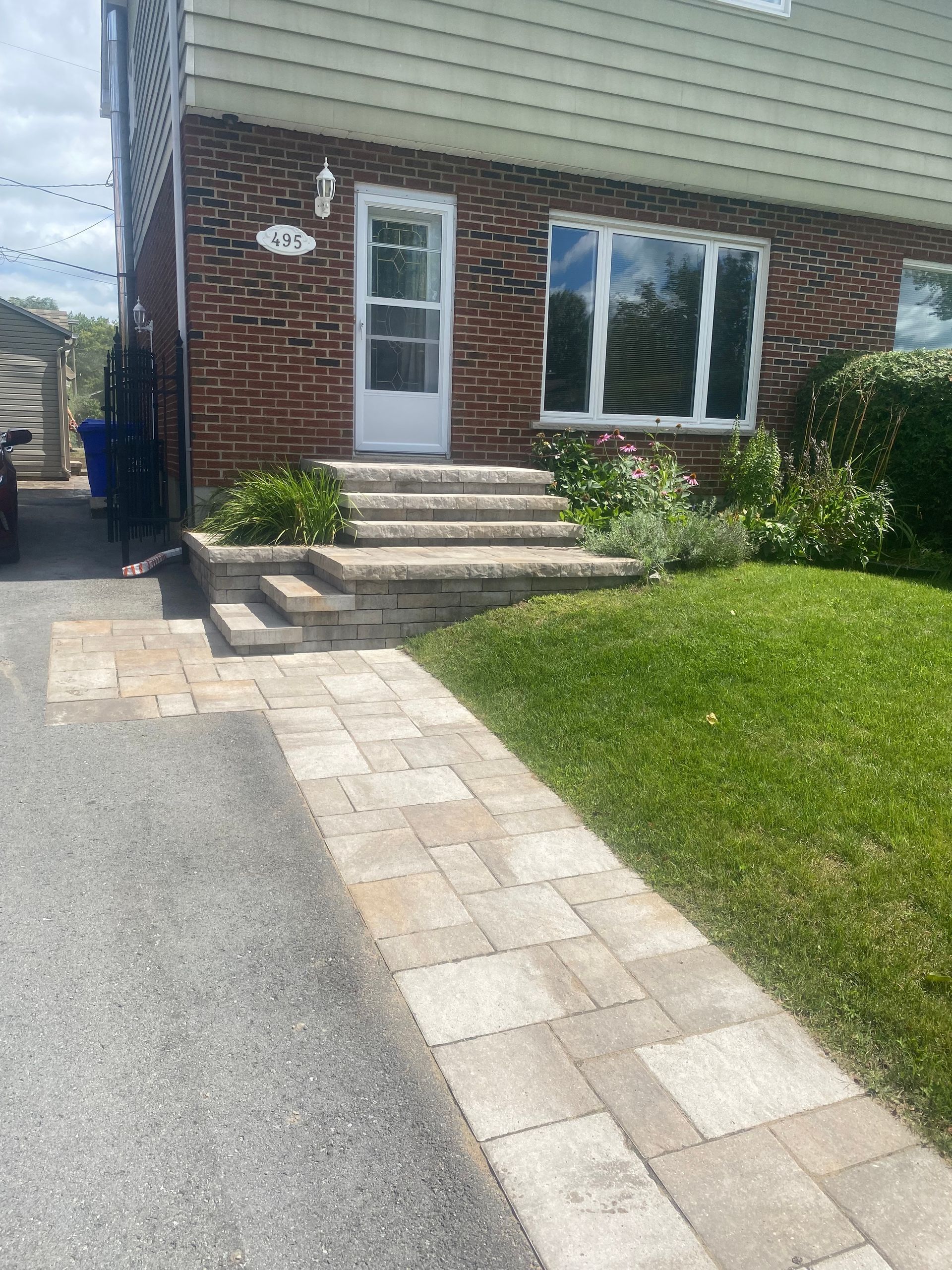Une maison en briques avec des escaliers menant à la porte d'entrée.