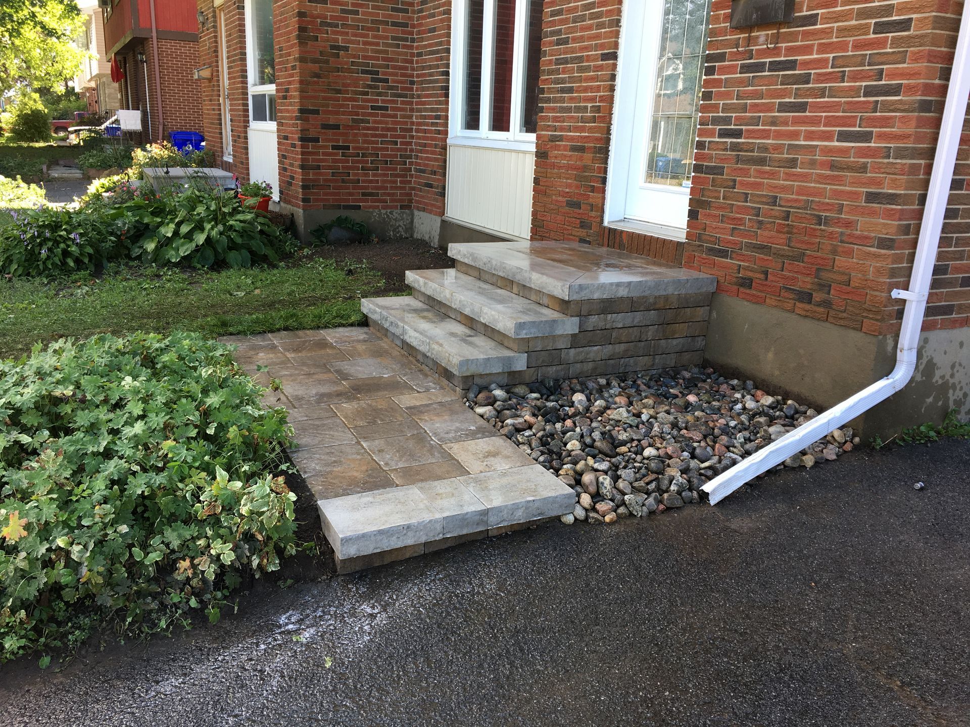 Une maison en briques avec des marches menant à la porte d'entrée.
