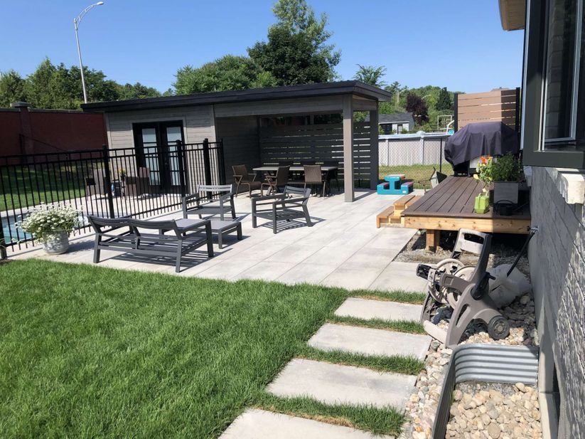 Une cour arrière avec un patio, des tables de pique-nique et un gazebo.