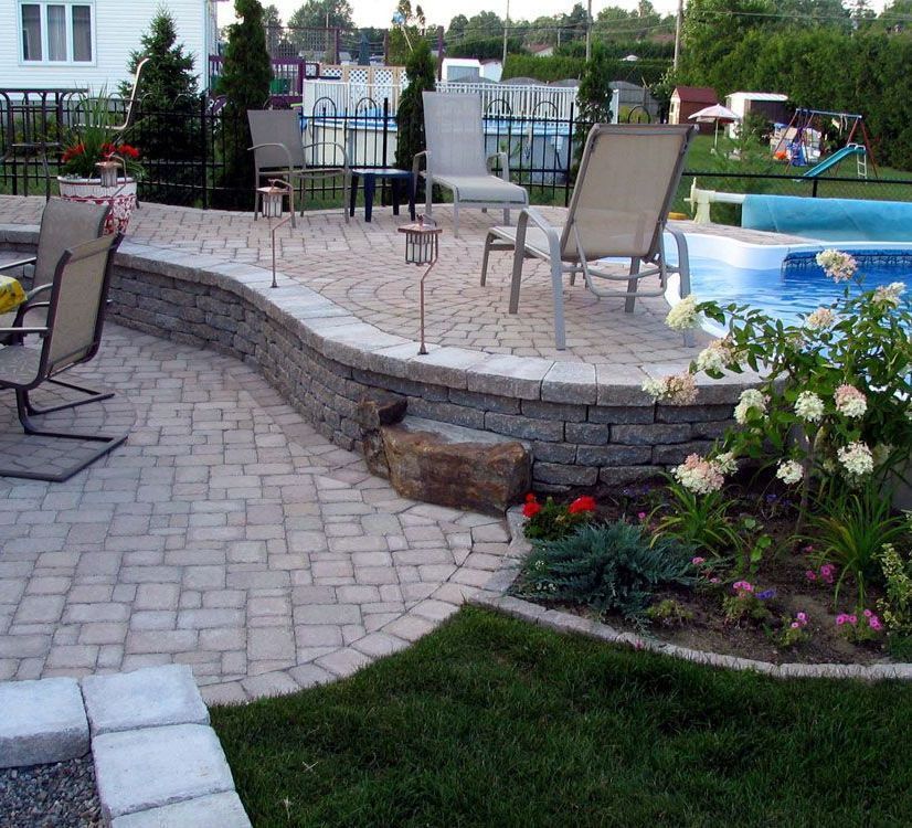 Un patio avec des chaises et une piscine en arrière-plan