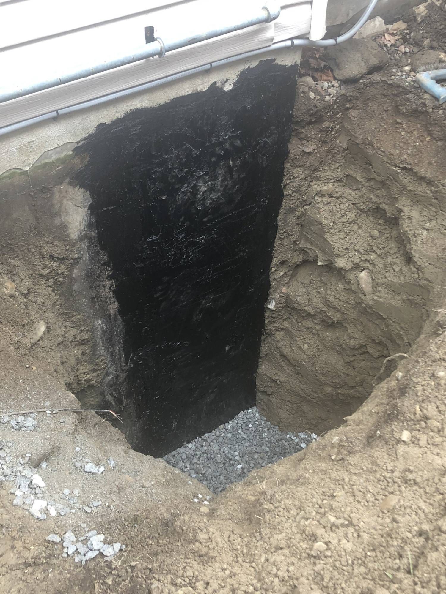 Un grand trou dans le sol à côté d'une maison.