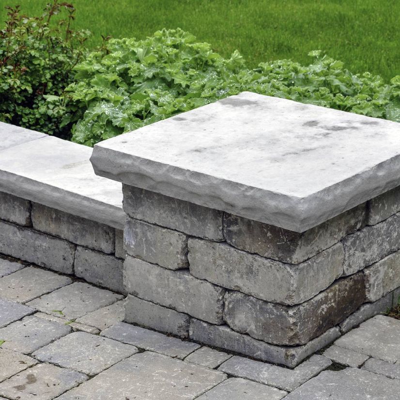 Un mur de briques avec un banc en pierre au-dessus