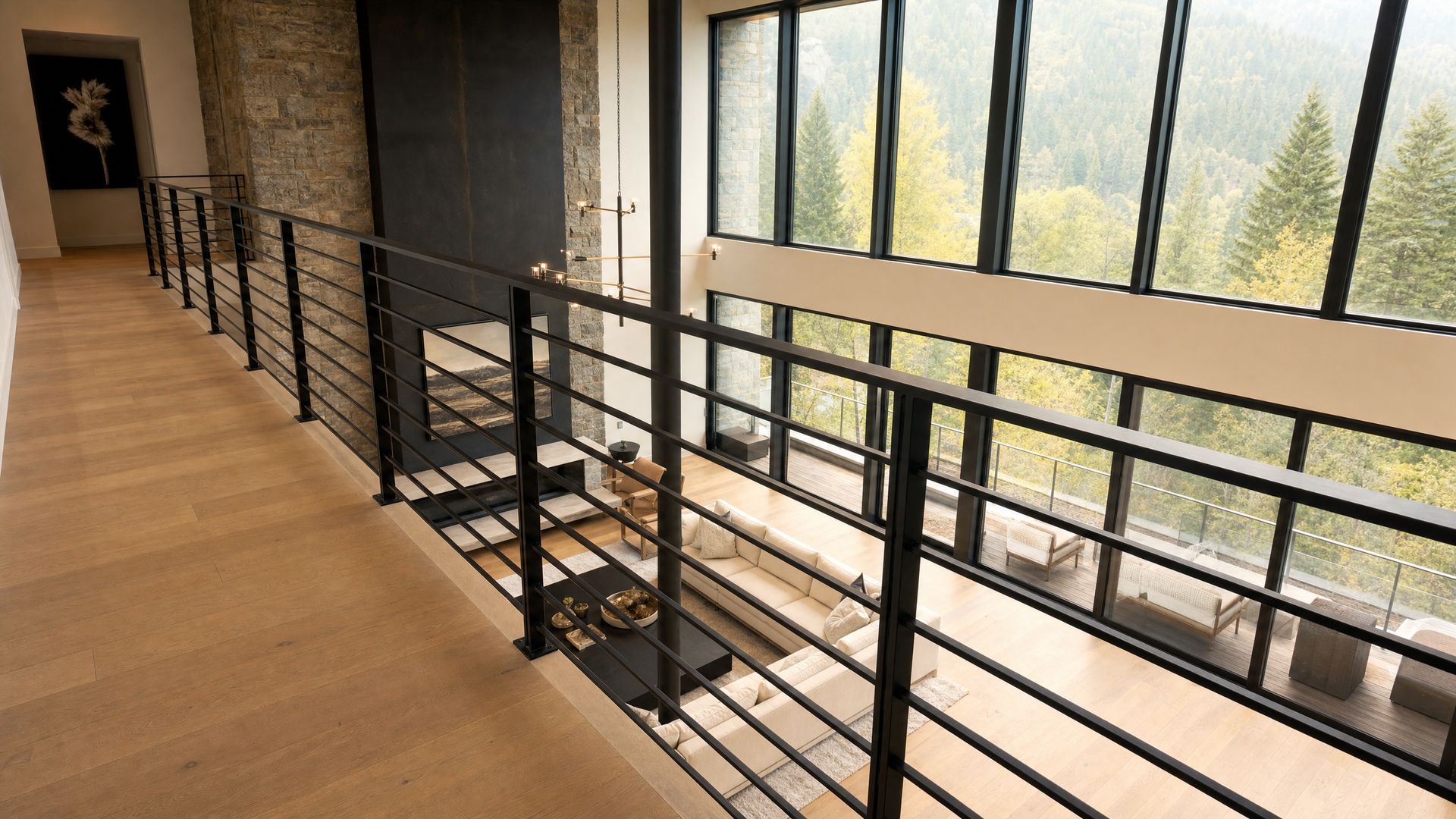 Modern interior hallway with black railing, wooden floor, and large windows overlooking trees